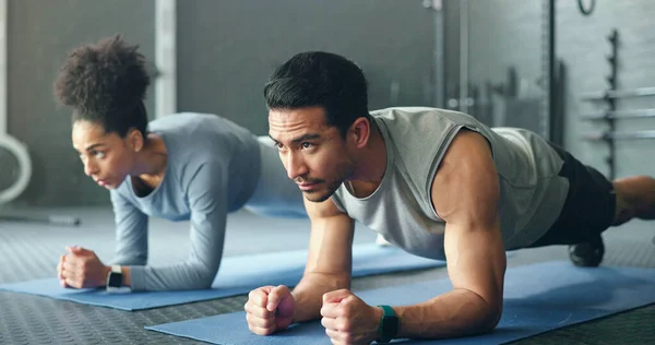 Couple, fitness and gym workout of training friends together for a core strength exercise for abs. Strong, sports and athlete wellness cardio of people doing a sport in a health club or studio.