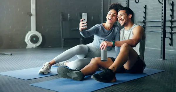 Selfie, fitness and couple training with a phone, happy with workout and smile for exercise at the gym. Wellness, photo and man and woman with love for sports and live streaming on social media.