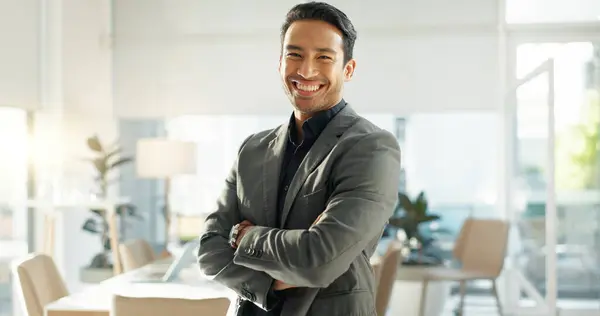 Crossed arms, happy and business Asian man in office for leadership, empowerment and success. Corporate, manager and portrait of person with funny joke in workplace for ambition, pride and confidence.