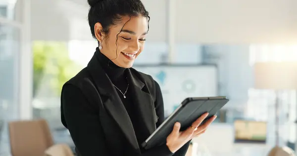 Happy businesswoman in office with tablet, email or social media for business feedback, schedule or agenda. Smile, digital app and woman networking online for market research, web review and report