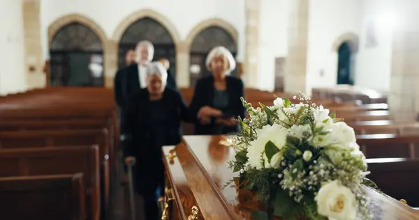 Funeral, church and people with coffin for goodbye, mourning and grief in memorial service. Depression, family and sad senior women with casket in chapel for greeting, loss and burial for death.