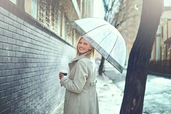 Woman, umbrella and coffee in street with portrait, smile and walking for commute in winter in city. Person, trench coat and outdoor for fashion on metro road with coco, tea cup or happy in Cape Town.