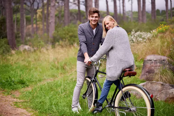 Couple, portrait and forest with retro bicycle on holiday, adventure and date with sustainable transport. Man, woman and vintage bike with smile for holiday with journey in woods, path or environment.