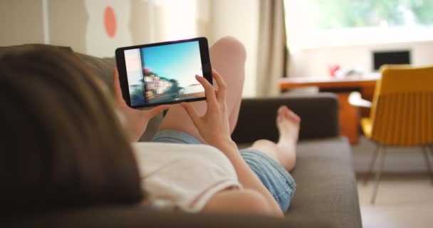 집에서 거실에서 미디어에 사진을 태블릿 아파트에서 소파에서 휴식을 취하는 디지털 — 비디오