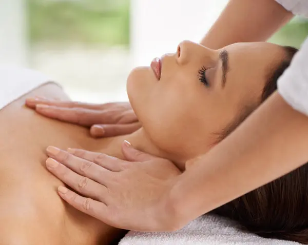 Woman, relax and body massage in spa for rest, wellness and peace with sleeping of healing hands. Person, comfort and masseuse for health treatment with zen, calm and detox on bed in holiday resort.
