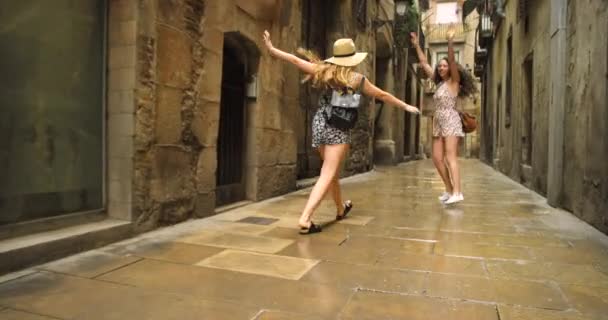 朋友和游客在城市里 兴奋地跳着走着 滑稽地一起在西班牙探险 人和游戏玩乐 欢笑或带着背包在巴塞罗那的小巷里旅行 — 图库视频影像