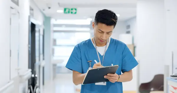 Doctor, planning and writing in documents, medical checklist or charts for hospital notes or clinic service. Healthcare worker, asian man or nurse smile for clipboard, paperwork or thinking in clinic.