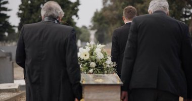 Erkekler, tabut ve tabutu taşıyanlar mezarlığın dışındaki törende yürüyorlar. Cenaze töreninde ölüm, keder ve grup tabutu, rüzgarlı bir günde yas tutan insanların mezarlığına ve aile servisine taşınır.