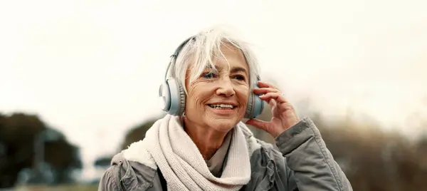 古い女性 ヘッドフォン 音楽アウトドアを聴く オーディオストリーミングとエネルギーでウォーキングとウェルネス ポッドキャスト ラジオと都市橋に女性の人とサウンド エクササイズとテクノロジーで旅行 — ストック写真
