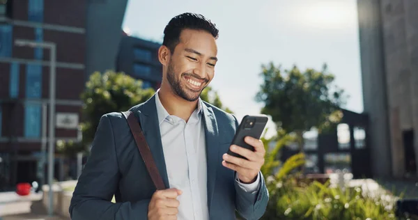 Business man, phone text and city with entrepreneur, smile and happy from morning commute and travel. Confidence, view and urban building with an male professional with social media and mobile.