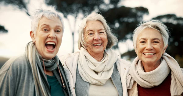 Comic, laughing and senior woman friends outdoor in a park together for bonding during retirement. Portrait, smile and funny with a group of elderly people chatting in a garden for humor or fun.