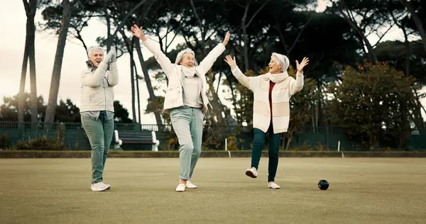 Senior women, celebration and park for sport, lawn bowling and happy for fitness, goal or applause in nature. Teamwork, elderly lady friends and metal ball for games, contest or win together on grass.