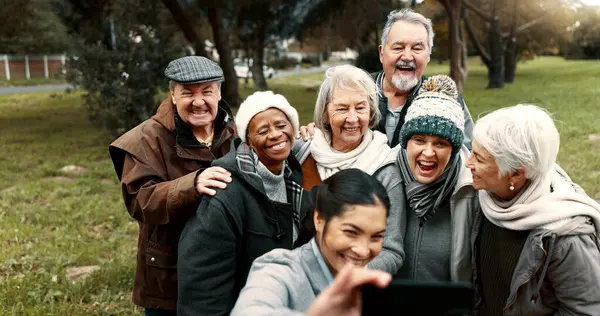 Nature, selfie and senior friends with woman while walking in outdoor garden for fresh air. Diversity, happy and group of elderly people in retirement taking picture with young female person in park