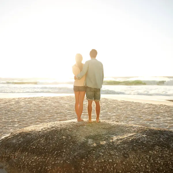 Sunset beach, love and back of couple in nature with hug, support and bonding, travel or vacation. Summer, mockup and people embrace at sunrise with sunshine, ocean view or date at sea in Florida.