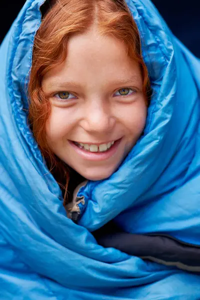 Sleeping bag, camping and portrait of child in tent for rest, relax and comfortable in gear. Travel, youth and face of ginger girl in sleep sack for adventure on holiday, vacation or weekend outdoors.