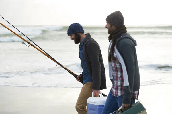 钓鱼和男人一起在海滩上散步 与凉爽 钓具盒和假日的对话 在海上寒假的早上 渔民和朋友们带着钓竿 鱼饵和工具在波浪中畅游 — 图库照片