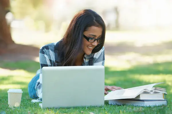Laptop, grass or happy woman in park with books for learning knowledge, information or education. Smile, textbooks or female student in nature for studying history or typing online on college campus.