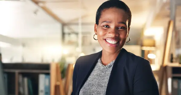 Face, happy and black woman in office at night for business on a computer during overtime. Smile, workspace and portrait of an African employee with a pc for a late deadline or working in corporate.