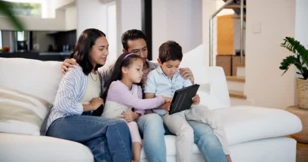 stock video Family, tablet and laughing at video on sofa of living room in home together for weekend bonding. Technology, streaming or entertainment with mother, father and children searching meme in apartment.