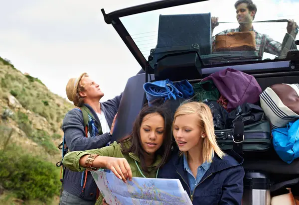 Friends, group and car with map for travel in mountain with bag luggage in trunk for bonding vacation, journey or explore. Men, women and location search in Italy for camping, adventure or holiday.