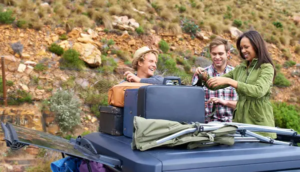 Friends, group and luggage on car roof for road trip together or camping holiday as explore, mountain or vacation. Men, woman and unloading bags on vehicle in Italy or travel, journey or suitcase.