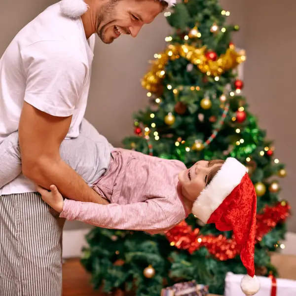 Father, son and happy with bonding on christmas for celebration, playing and love in the morning with santa hats. Family, man and child with smile, relax and enjoying holiday season in lounge of home.