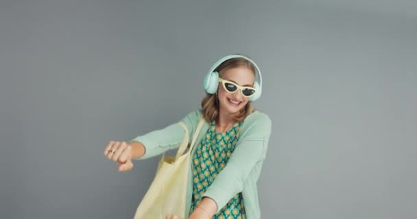 Woman Studio Dancing Music Headphone Shopper Sunglasses Grey Background Joy — Stock Video