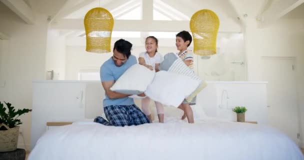 子供たち 幸せな枕はベッドで戦い 家で休日に絆を結んで遊んでいます 寝室および面白いゲームのための興奮する父 家族の家で笑顔の兄弟および姉妹 — ストック動画