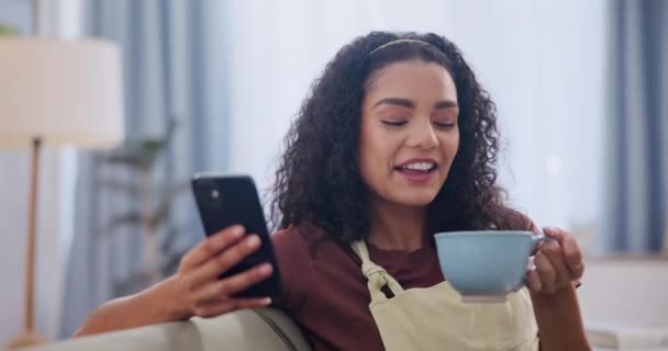 电话和咖啡与妇女在沙发上的客厅里的沟通或网络 应用程序和社交媒体 快乐的年轻人在公寓里喝着热饮放松 — 图库视频影像