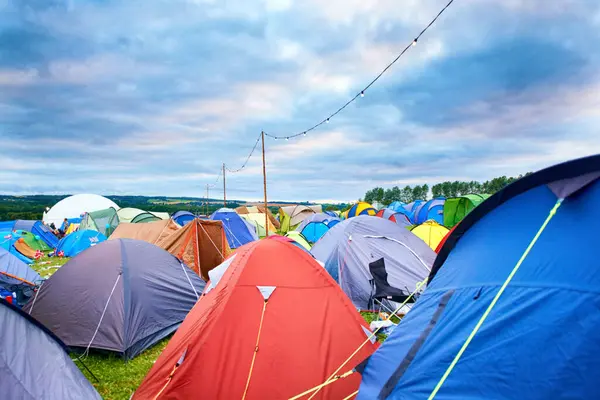Camping, tents and outdoor music festival in park on holiday or vacation in summer. Camp, site and shelter setup at party, event or travel in countryside for concert, adventure and crowded carnival.
