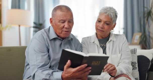 シニア カップル 家庭では聖書を読み 神について話したり ソファーで聖書の霊的なガイドを助けたりします 高齢者 キリスト教の女性 宗教と支援のための聖書 — ストック動画