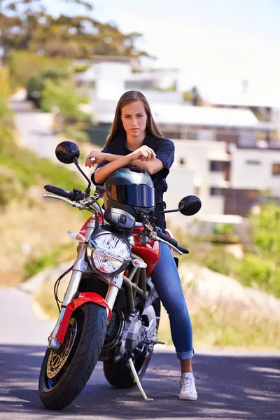 Woman, portrait and motorcycle in city with helmet for road trip, travel or outdoor journey in nature. Extreme female person or biker in confidence for ride, transport or sightseeing in an urban town.