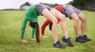 Çift, esnemek için egzersiz ve çimen yazın spor yapmak için kemer ya da egzersiz. İngiltere 'de çimenlikte insanlar, eğitim veya kas sağlığı, denge, sağlık veya doğa için esneklik.