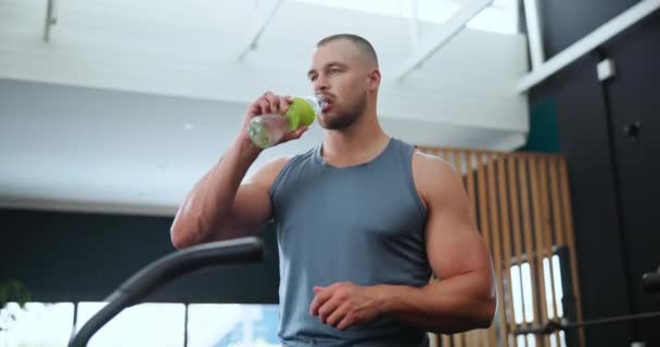 健康和与男人一起在健身房喝水的水合 以便休息或从锻炼中恢复 运动或健康 有自信的年轻健美运动员 训练时喝玻璃瓶 — 图库视频影像
