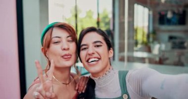 Kafe, selfie ve masada barış işareti olan mutlu lezbiyen kadınlar sosyal medya paylaşımına gülüyorlar. Gülümse, fotoğrafçılık ve Igbt çifti kaldırımdaki kahve dükkanında gururla, seyahatle ve hafızayla sarılıyorlar.