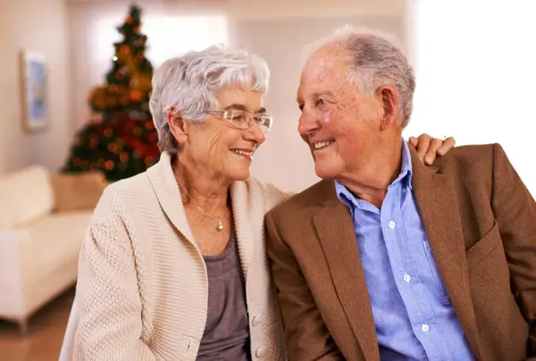クリスマス ハグと愛と古いカップル 結婚とお祝いの季節との笑顔とロマンス ホーム クリスマスツリーと高齢女性と抱き合う 退職やお祝いとのシニアマンと関係 — ストック写真