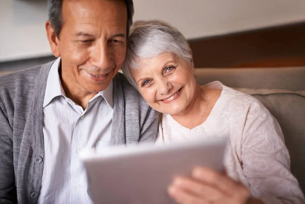 年长的夫妇和肖像画与平板在沙发上在线宾果 填字游戏和网络游戏与微笑 老年人 男人和女人都有脸和幸福与技术在家庭的网络新闻 — 图库照片