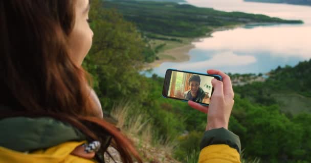 ビデオ通話 屋外での挨拶 インターネット接続 電話でのコミュニケーション カップル 自然の冒険 モバイルアプリで愛と結合に関するキスと仮想会話 — ストック動画