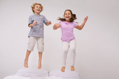 Zıplama, yatak ve çocuklu mutlu, eğlenceli bir yatak odasında oyun ve kardeşle bir sabah. Gençlik, hoplayıp zıpla ve heyecan dolu çocuklar havadayken çılgın, evdeki enerjiyle oynayan ve gülen aile..