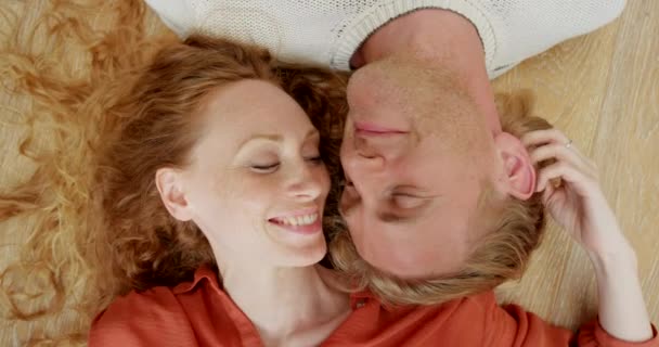 放松和微笑与夫妇在地板上从上的结合 浪漫和幸福 有爱心的 年轻的 相亲相爱的男人和女人躺在家里的客厅里 一起承诺 一起休息 — 图库视频影像