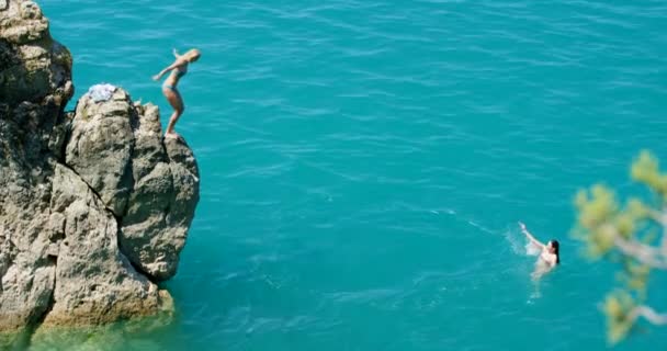为了热带岛屿 度假或夏天的游泳探险 朋友和悬崖跳到海里 在法国或欧洲旅行 旅行或周末 女性勇敢无畏 勇往直前 — 图库视频影像