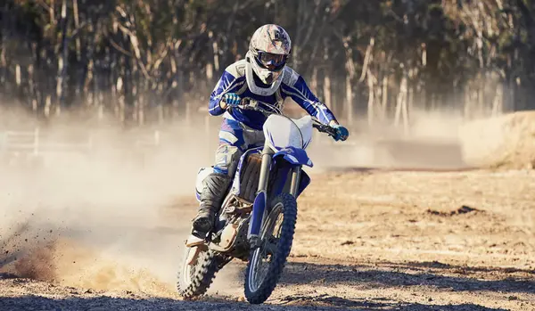 Motorcycle, action and speed with person riding on dirt track, adrenaline and skill for extreme sports outdoor. Competition, adventure and power with risk, fast with biker on motorbike for race.