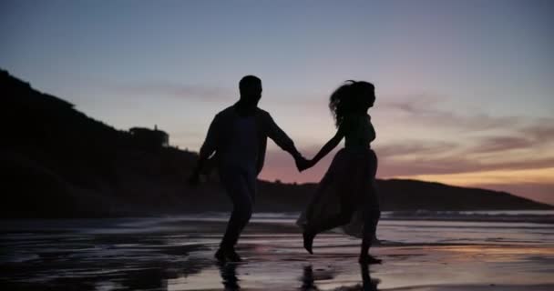 ロマンチックなデートのためのビーチでカップルの夕日 ランニング シルエット 一緒にバレンタインのための熱帯週末の旅行に手を握る愛 — ストック動画