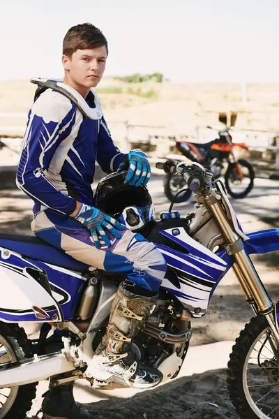 Motorbike, extreme sport and portrait for man on trail for competition, race and games with speed. Person, motorcycle and pride for contest, motor cross or fast transportation with sunshine in desert.
