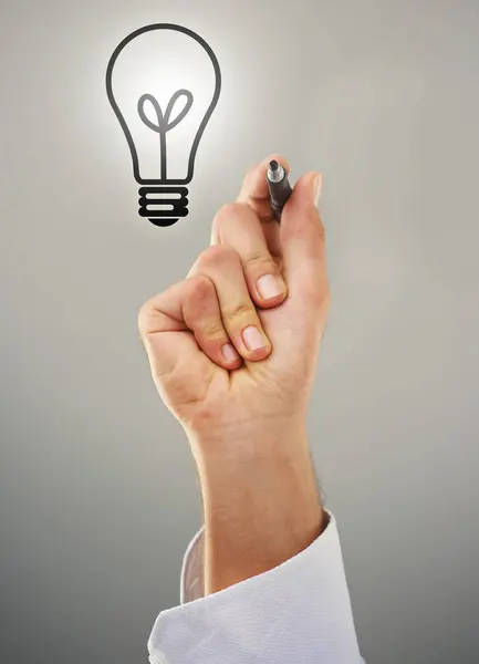 Hand, light bulb and drawing with ideas for business growth and development on grey background. Person brainstorming, corporate innovation and knowledge for enlightenment, inspiration and insights.