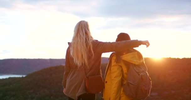 そして自然の中での冒険の自由 または旅のための山の日没にハグします 友情のバックパックで景色 日差し ハイキングを楽しむ女性のリアビュー — ストック動画