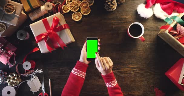 緑色のスクリーンの手 携帯電話およびクリスマスのコーヒー 配達または包装の提示は上の眺めにあります スタジオやブティックでオンラインショッピング製品を梱包する箱 お祝い ビジネスワーカー — ストック動画