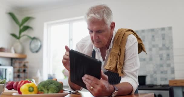 搜索和老年人做饭在厨房与在线食谱 膳食准备或蔬菜配料检查 应用和老年男性退休后享受美食 博客或早午餐的乐趣 — 图库视频影像