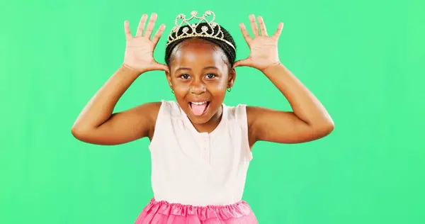 Children, playful and princess with a black girl on a green screen background in studio feeling silly or goofy. Kids, cute and happy with an adorable little girl playing or having fun on chromakey.