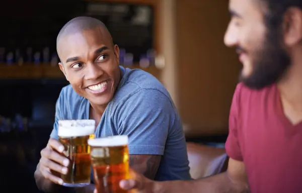 Friends, man and happiness in pub with beer for happy hour, relax or social event with cheers. Diversity, people and drinking alcohol in restaurant or club with smile for bonding and celebration.